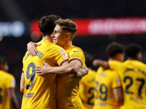 Barcelona's Spanish midfielder #32 Fermin Lopez celebrates scoring his team's third goal with Barcelona's Polish forward #09 Robert Lewandowski during the Spanish league football match between Club Atletico de Madrid and FC Barcelona at the Metropolitano stadium in Madrid on March 17, 2024. (Photo by OSCAR DEL POZO / AFP)