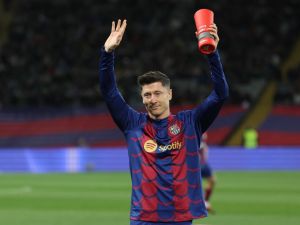 Barcelona's Polish forward #09 Robert Lewandowski waves as he holds La Liga Best Player of the Month trophy before the Spanish league football match between FC Barcelona and RCD Mallorca at the Estadi Olimpic Lluis Companys in Barcelona on March 8, 2024. (Photo by LLUIS GENE / AFP)