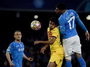 Barcelona's Spanish forward #27 Lamine Yamal (C) vies with Napoli's Uruguayan defender #17 Mathias Olivera (R) during the UEFA Champions League round of 16 first Leg football match between Napoli and Barcelona at the Diego-Armando-Maradona stadium in Naples on February 21, 2024. (Photo by Filippo MONTEFORTE / AFP)