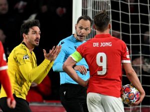 Dortmund's German defender #15 Mats Hummels (L) reacts towards PSV's Dutch forward #09 Luuk de Jong during a penalty shoot following Hummels' foul as Serbian football referee Srdan Jovanovic looks on during the UEFA Champions League round of 16, first leg football match between against PSV Eindhoven and Borussia Dortmund at the The Philips Stadium, in Eindhoven on February 20, 2024. (Photo by JOHN THYS / AFP)