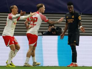 Leipzig's Dutch midfielder #20 Xavi Simons (L) and Leipzig's German midfielder #22 David Raum protest at Real Madrid's Brazilian forward #07 Vinicius Junior for being to close for the corner kick during the UEFA Champions League Round of 16, first-leg football match between RB Leipzig and Real Madrid CF in Leipzig, eastern Germany, on February 13, 2024. (Photo by Odd ANDERSEN / AFP)