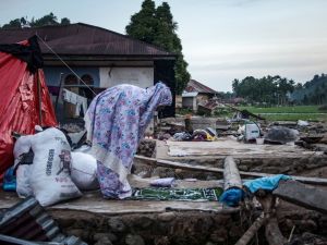 A Muslim woman offers prayers during the Islamic holy month of Ramadan as she and her family members live in the temporary shelters after a flash flood destroyed their home in Ganting, West Sumatra on March 14, 2024. (Photo by REZAN SOLEH / AFP) Indonesia landslide leaves dozens killed