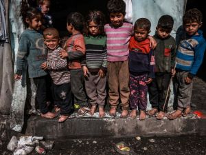 Displaced Palestinian children pose for photos standing in front of makeshift tents at a camp beside a street in Rafah on March 14, 2024, amid ongoing battles between Israel and the Hamas militant group. The Israel-Hamas conflict raging since October 7 has caused mass civilian deaths, reduced vast areas to a rubble-strewn wasteland and sparked warnings of looming famine in the Palestinian territory of 2.4 million people. (Photo by Mohammed ABED / AFP) Gaza Children