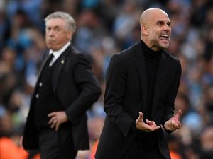 Manchester City's Spanish manager Pep Guardiola (R), watched by Real Madrid's Italian coach Carlo Ancelotti, celebrates the opening goal during the UEFA Champions League second leg semi-final football match between Manchester City and Real Madrid at the Etihad Stadium in Manchester, north west England, on May 17, 2023. (Photo by Oli SCARFF / AFP)