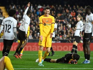 Barcelona's Polish forward #09 Robert Lewandowski (C) reacts as Valencia's Georgian goalkeeper #25 Giorgi Mamardashvili holds the ball during the Spanish league football match between Valencia CF and FC Barcelona at the Mestalla stadium in Valencia on December 16, 2023. (Photo by JOSE JORDAN / AFP)