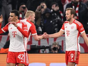 Bayern Munich's English forward #09 Harry Kane (R) celebrates scoring the 3-0 with his team-mates Bayern Munich's Dutch defender #04 Matthijs de Ligt (C) and Bayern Munich's German midfielder #42 Jamal Musiala during the UEFA Champions League round of 16, second-leg football match between FC Bayern Munich and Lazio in Munich, southern Germany on March 5, 2024. (Photo by Kirill KUDRYAVTSEV / AFP)