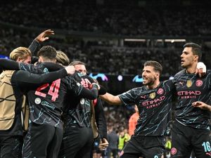 Manchester City's players celebrate English midfielder #47 Phil Foden second goal during the UEFA Champions League quarter final first leg football match between Real Madrid CF and Manchester City at the Santiago Bernabeu stadium in Madrid on April 9, 2024. (Photo by JAVIER SORIANO / AFP)