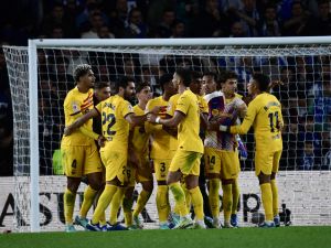 Barcelona's Uruguayan defender #04 Ronald Araujo (L) and teammates celebrate victory at the end of the Spanish league football match between Real Sociedad and FC Barcelona at the Anoeta stadium in San Sebastian on November 4, 2023. Barcelona won 0-1. (Photo by ANDER GILLENEA / AFP)