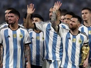 Argentina's forward Lionel Messi (R) waves at the crowd while holding a replica of the World Cup trophy next to his teammates during a recognition ceremony for the World Cup-winning players, following the friendly football match between Argentina and Curacao at the Madre de Ciudades stadium in Santiago del Estero, in northern Argentina, on March 28, 2023. (Photo by Alejandro PAGNI / AFP)