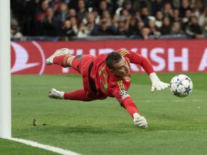 Real Madrid's Ukrainian goalkeeper #13 Andriy Lunin stops the ball during the UEFA Champions League group C football match between Real Madrid CF and SC Braga at the Santiago Bernabeu stadium in Madrid on November 8, 2023. (Photo by Thomas COEX / AFP)