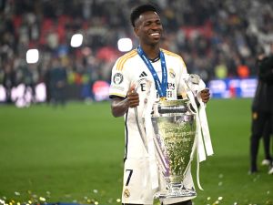 Real Madrid's Brazilian forward #07 Vinicius Junior poses with the trophy to celebrate the victory at the end of the UEFA Champions League final football match between Borussia Dortmund and Real Madrid, at Wembley stadium, in London, on June 1, 2024. (Photo by INA FASSBENDER / AFP)