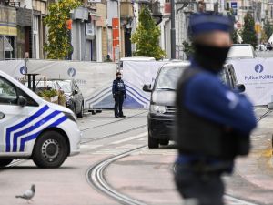 Police officers stand guard in front of the house in the Schaerbeek area of Brussels on October 17, 2023, where the suspected perpetrator of the attack in Brussels was shot dead during a police intervention. (Photo by JOHN THYS / AFP) Belgium
