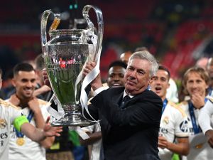 Real Madrid's Italian coach Carlo Ancelotti lifts the trophy to celebrate the victory at the end of the UEFA Champions League final football match between Borussia Dortmund and Real Madrid, at Wembley stadium, in London, on June 1, 2024. (Photo by Glyn KIRK / AFP)