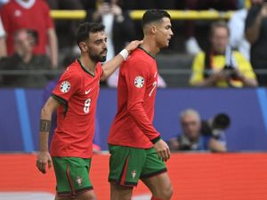 Portugal's midfielder #08 Bruno Fernandes celebrates with Portugal's forward #07 Cristiano Ronaldo (R) after scoring his team's third goal during the UEFA Euro 2024 Group F football match between Turkey and Portugal at the BVB Stadion in Dortmund on June 22, 2024. (Photo by PATRICIA DE MELO MOREIRA / AFP)