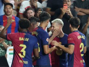 Barcelona's Spanish midfielder #20 Dani Olmo celebrates with teammates scoring his team's second goal during the Spanish league football match between Rayo Vallecano de Madrid and FC Barcelona on August 27, 2024. (Photo by Pierre-Philippe MARCOU / AFP)