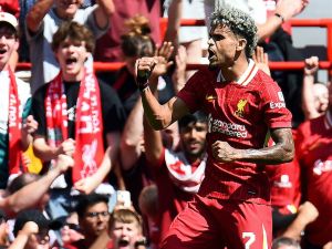 Liverpool's Colombian midfielder #07 Luis Diaz celebrates scoring the team's second goal during the pre-season friendly football match between Liverpool and Sevilla at Anfield stadium in Liverpool, northwest England on August 11, 2024. (Photo by Peter POWELL / AFP)