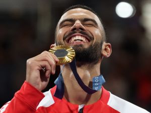 Gold medallist Tunisia's Firas Katoussi celebrates on the podium during the medal ceremony for the taekwondo men's -80kg competition of the Paris 2024 Olympic Games at the Grand Palais in Paris on August 9, 2024. (Photo by David GRAY / AFP)