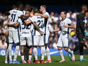 Inter Milan's French forward #09 Marcus Thuram is mobbed by teammates after scoring the opening goal during the pre-season friendly football match between Chelsea and Inter Milan at the Stamford Bridge stadium in London on August 11, 2024. (Photo by JUSTIN TALLIS / AFP)