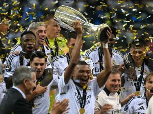 Real Madrid's French forward #09 Kylian Mbappe celebrates with the trophy after the UEFA Super Cup football match between Real Madrid and Atalanta BC in Warsaw, on August 14, 2024. (Photo by Sergei GAPON / AFP)