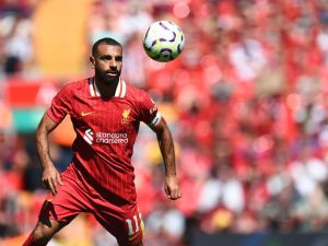 Liverpool's Egyptian striker #11 Mohamed Salah focuses on the ball during the pre-season friendly football match between Liverpool and Sevilla at Anfield stadium in Liverpool, northwest England on August 11, 2024. (Photo by Peter POWELL / AFP)