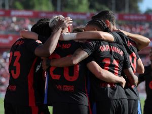 Barcelona's Spanish forward #20 Daniel Olmo celebrates with teammates scoring his team's third goal during the Spanish league football match between Girona FC and FC Barcelona at the Montilivi stadium in Girona on September 15, 2024. (Photo by LLUIS GENE / AFP)