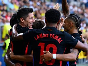 Barcelona's Polish forward #09 Robert Lewandowski celebrates with teammates after scoring his team's first goal during the Spanish league football match between Villarreal CF and FC Barcelona at La Ceramica stadium in Vila-real, on September 22, 2024. (Photo by JOSE JORDAN / AFP)