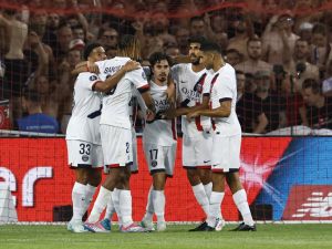 Paris Saint-Germain's Portuguese midfielder #17 Vitinha (C) is congratulated by teammates after scoring PSG's first goal during the French L1 football match between Lille LOSC and Paris Saint-Germain (PSG) at the Stade Pierre-Mauroy in Villeneuve-d'Ascq, northern France, on September 1, 2024. (Photo by DENIS CHARLET / AFP)