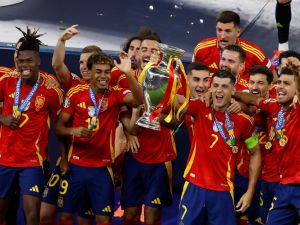 Spain's players celebrate with the trophy after winning the UEFA Euro 2024 final football match between Spain and England at the Olympiastadion in Berlin on July 14, 2024. (Photo by Odd ANDERSEN / AFP)