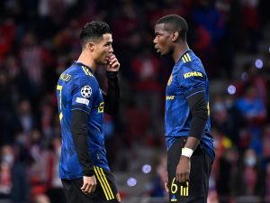 Manchester United's Portuguese forward Cristiano Ronaldo (L) speaks with Manchester United's French midfielder Paul Pogba before the start of the UEFA Champions League football match between Atletico de Madrid and Manchester United at the Wanda Metropolitano stadium in Madrid on February 23, 2022. (Photo by OSCAR DEL POZO / AFP)