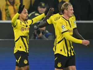 Dortmund's Dutch forward #21 Donyell Malen celebrates scoring the opening goal with his teammates Dortmund's Guinean forward #09 Serhou Guirassy and Dortmund's German midfielder #10 Julian Brandt during the UEFA Champions League football match BVB Borussia Dortmund vs SK Sturm Graz in Dortmund, western Germany on November 5, 2024. (Photo by INA FASSBENDER / AFP)
