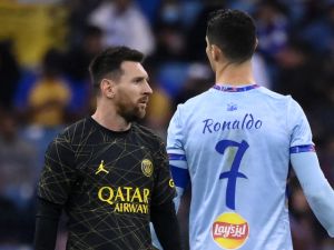 Paris Saint-Germain's Argentine forward Lionel Messi (L) walks past Riyadh All-Star's Portuguese forward Cristiano Ronaldo (R) during the Riyadh Season Cup football match between the Riyadh All-Stars and Paris Saint-Germain at the King Fahd Stadium in Riyadh on January 19, 2023. (Photo by FRANCK FIFE / AFP)