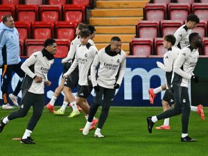 Real Madrid's English midfielder #5 Jude Bellingham (L) and Real Madrid's French forward #09 Kylian Mbappe (C) take part in a training session, at Anfield Stadium in Liverpool, north west England, on November 26, 2024, on the eve of their UEFA Champions League football match against Liverpool. (Photo by Paul ELLIS / AFP)
