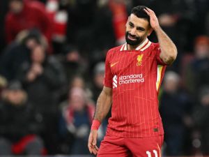 Liverpool's Egyptian striker #11 Mohamed Salah reacts after failing to score from the penalty spot during the UEFA Champions League football match between Liverpool and Real Madrid at Anfield in Liverpool, north west England on November 27, 2024. (Photo by Oli SCARFF / AFP)