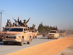 Anti-government fighters ride military vehicles as they drive along a road in the eastern part of Aleppo province on December 1, 2024. (Photo by Aref TAMMAWI / AFP) Abu Mohammad al-Julani