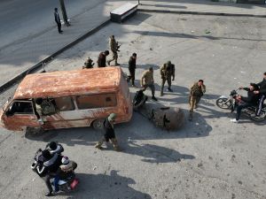  anti government fighters towing a bust of late Syrian president Hafez al-Assad along a street in the city of Hama