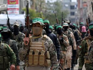 Palestinian fighters from the Ezzedine al-Qassam Brigades, the armed wing of Hamas, take part in the funeral procession of Marwan Issa, a top Hamas commander killed in March 2024, in the war-devastated Bureij refugee camp in the central Gaza Strip on February 7, 2025. (Photo by Eyad BABA / AFP) Aid-for-weapons standoff: Unclear Gaza deal could spark a "Non-traditional conflict"