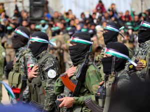 Palestinians and Hamas fighters gather shortly before the release of three Israeli hostages as part of the seventh hostage-prisoner swap, in Nuseirat in the central Gaza Strip on February 22, 2025. (Photo by Eyad BABA / AFP) Palestinian civilians