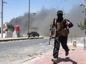 Heavy smoke rises as a member of Bedouin and tribal forces runs during clashes with Druze fighters in Syria's southern city of Sweida, despite an announcement by the Syrian interim president of an "immediate ceasefire" on July 19, 2025. (Photo by OMAR HAJ KADOUR / AFP) Jihadist Omar Omsen