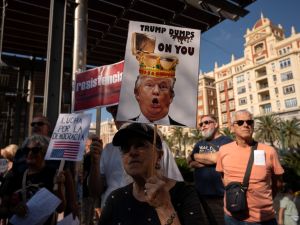 People participate in a protest against US President Donald Trump in Malaga, on October 18, 2025. (Photo by JORGE GUERRERO / AFP) 'No Kings' protests