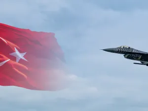 طائرة مقاتلة تركية من طراز سولوتورك F-16 تحلق أمام خلفية علم تركيا.