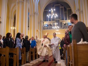 موسكو، روسيا. ليلة 30 إلى 31 مارس 2024. عيد القيامة في كاتدرائية كاثوليكية. يقوم الأسقف برشّ الناس بالماء المقدس.