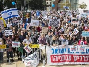 Israeli protesters raise signs as they demonstrate against Prime Minister Benjamin Netanyahu in the wake of police recommendations to indict corruption, in the coastal city of Tel Aviv on Feb. 16, 2018. 
(JACK GUEZ / AFP)