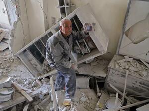 An elderly Syrian man shows a family picture after he recovered it from the rubble of his house in Kafar Batna in the Syrian rebel enclave of Eastern Ghouta on Mar. 1, 2018 following reported air strikes by Syrian government forces. 
Syrian and Russian forces kept up military pressure on rebel-held Eastern Ghouta today as their controversial unilateral truce failed to yield a humanitarian breakthrough.
(AMER ALMOHIBANY / AFP)