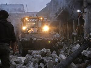 Members of the Syrian civil defence use a bulldozer to clear rubble as they search for survivors in the aftermath of an air strike in the rebel-held town of Harem in the northwestern Idlib province on Mar. 22, 2018. 
(Aaref WATAD / AFP)