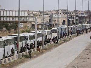 Hundreds of fighters and civilians from Harasta in Syria’s Eastern Ghouta sit on busses on Mar. 23, 2018 after a deal was struck with the opposition to evacuate a second pocket of the rebel enclave on the outskirts of Damascus. Harasta's evacuation came as part of a deal negotiated by Russia, which has played a key role in the deadly offensive launched against the enclave on Feb. 18. (STRINGER / AFP)