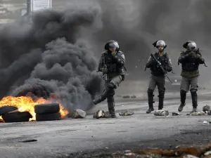 Israeli border guards walk through fumes from burning tires during clashes with Palestinian protesters near the Israeli settlement of Beit El in the Israeli occupied West Bank, on Mar. 30, 2018, after Land Day demonstrations. Land Day marks the killing of six Arab Israelis during 1976 demonstrations against Israeli confiscations of Arab land.
(ABBAS MOMANI / AFP)