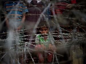 Rohingya refugees gather in the "no man's land" behind the Myanmar border lined with barb wire fences just inside Bangladesh (AFP/File Photo)