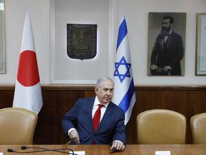 Israeli Prime Minister Benjamin Netanyahu sits in conference room before flags of Japan (L), Israel (C), and a portrait of Theodor Herzl (seen as "Visionary of the Jewish State" and founder of modern Zionism) at the PM office ahead of his meeting with his Japanese counterpart in Jerusalem on May 2, 2018. 
(Abir SULTAN / POOL / AFP)