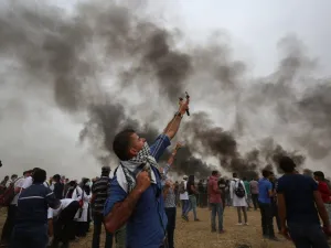 A Palestinian uses a slingshot during a protest demanding the right to return to their historic homeland at the Israel-Gaza border, east of Khan Yunis in the southern Gaza Strip, May 4, 2018. Hundreds of Palestinians gathered on the Gaza border Friday for the sixth week of protests in which dozens have already been killed by Israeli fire. (SAID KHATIB / AFP)