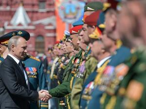 Russian President Vladimir Putin shakes hands with military personnel during the Victory Day parade at Red Square in Moscow on May 9, 2018 / AFP